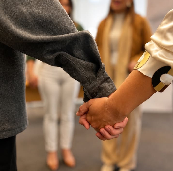 Participantes de mãos dadas durante dinâmica em grupo